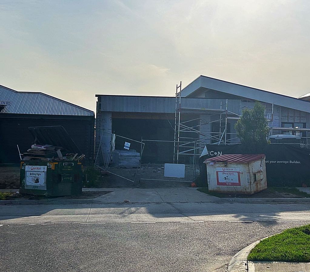 Builders clean out front of a job site